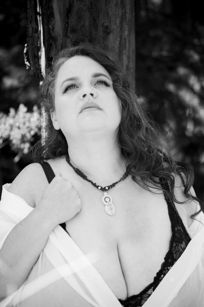 Fine art black and white boudoir photography in Utah capturing a confident woman in lace lingerie with natural light and soft contrast